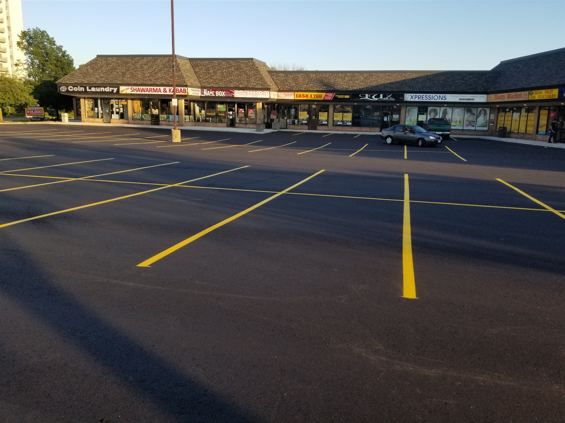 Commercial plaza parking lot with fresh yellow parking lines, from O'Brien Paving's project portfolio